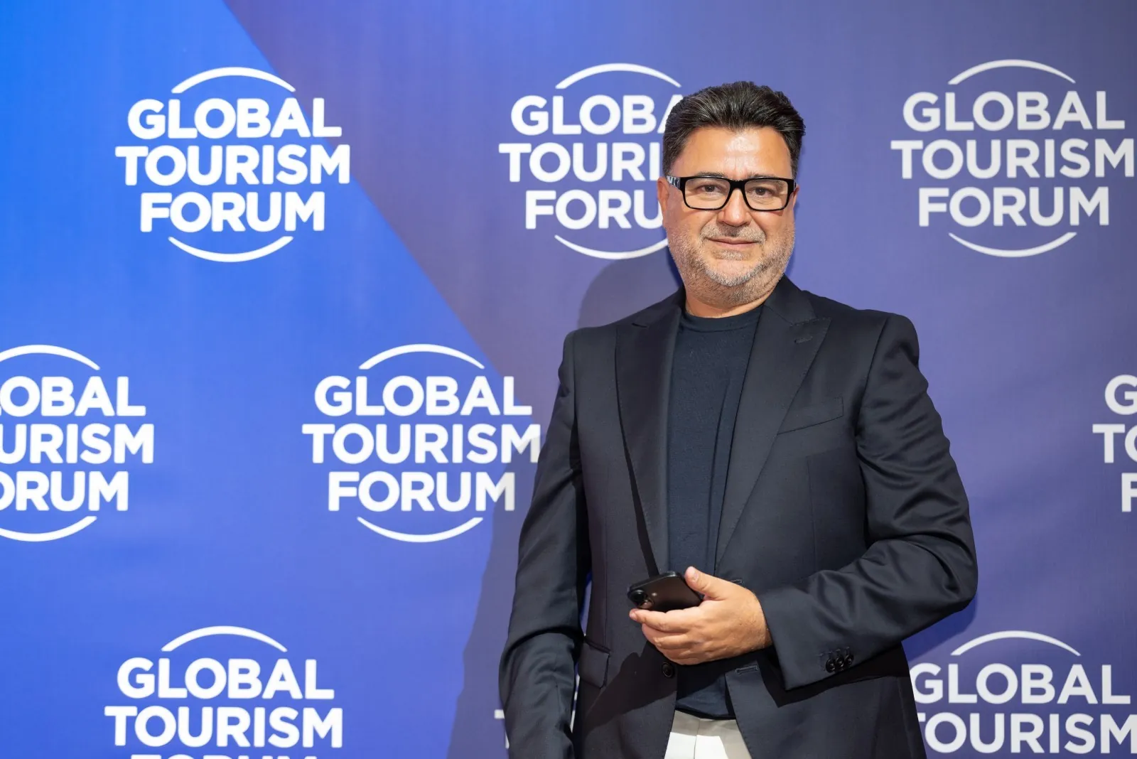 Wael Joujou, V-Marine’s founder, in a dark suit in front of a Global Tourism Forum backdrop
