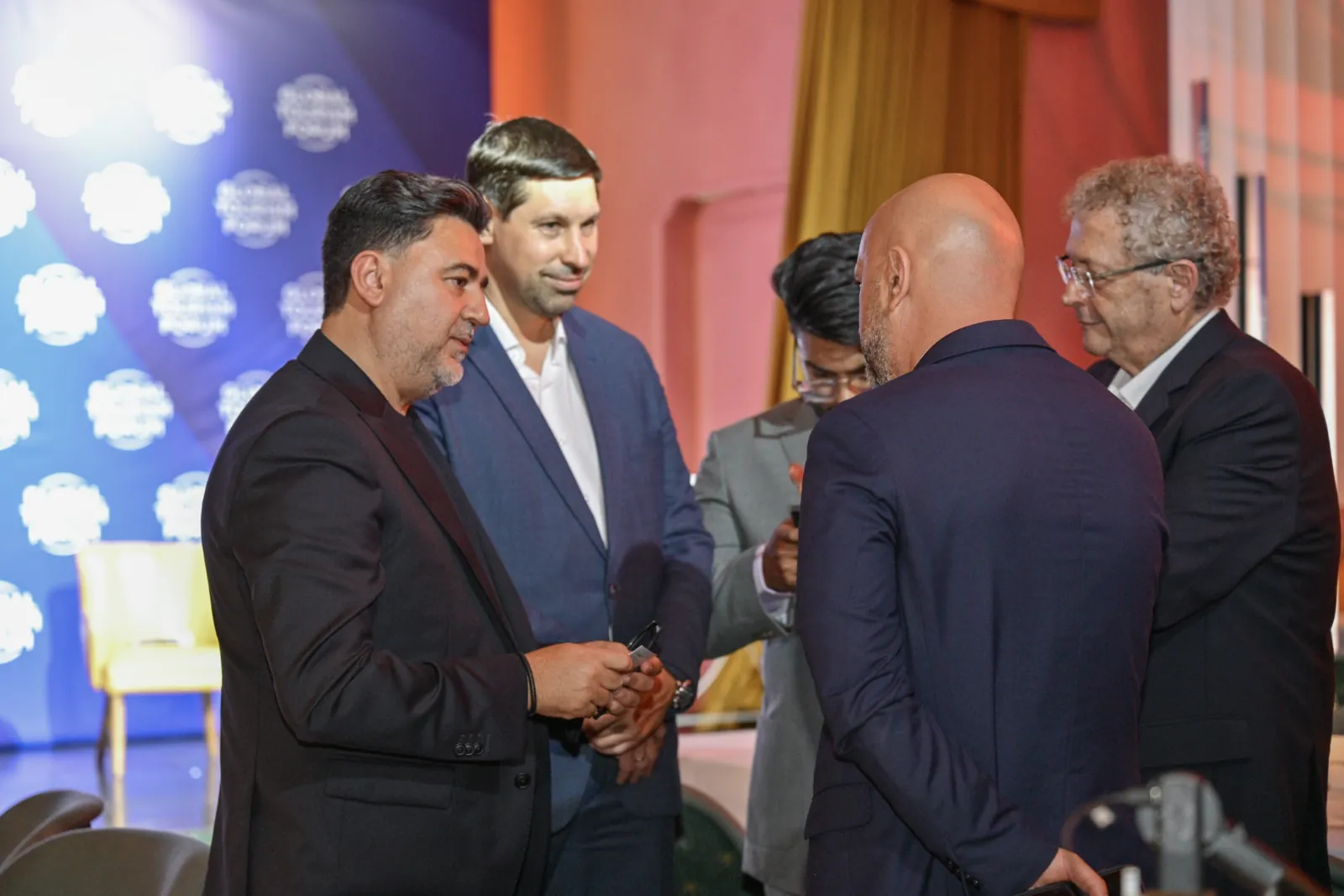 Guests talking at the Leaders Dinner under warm stage lighting