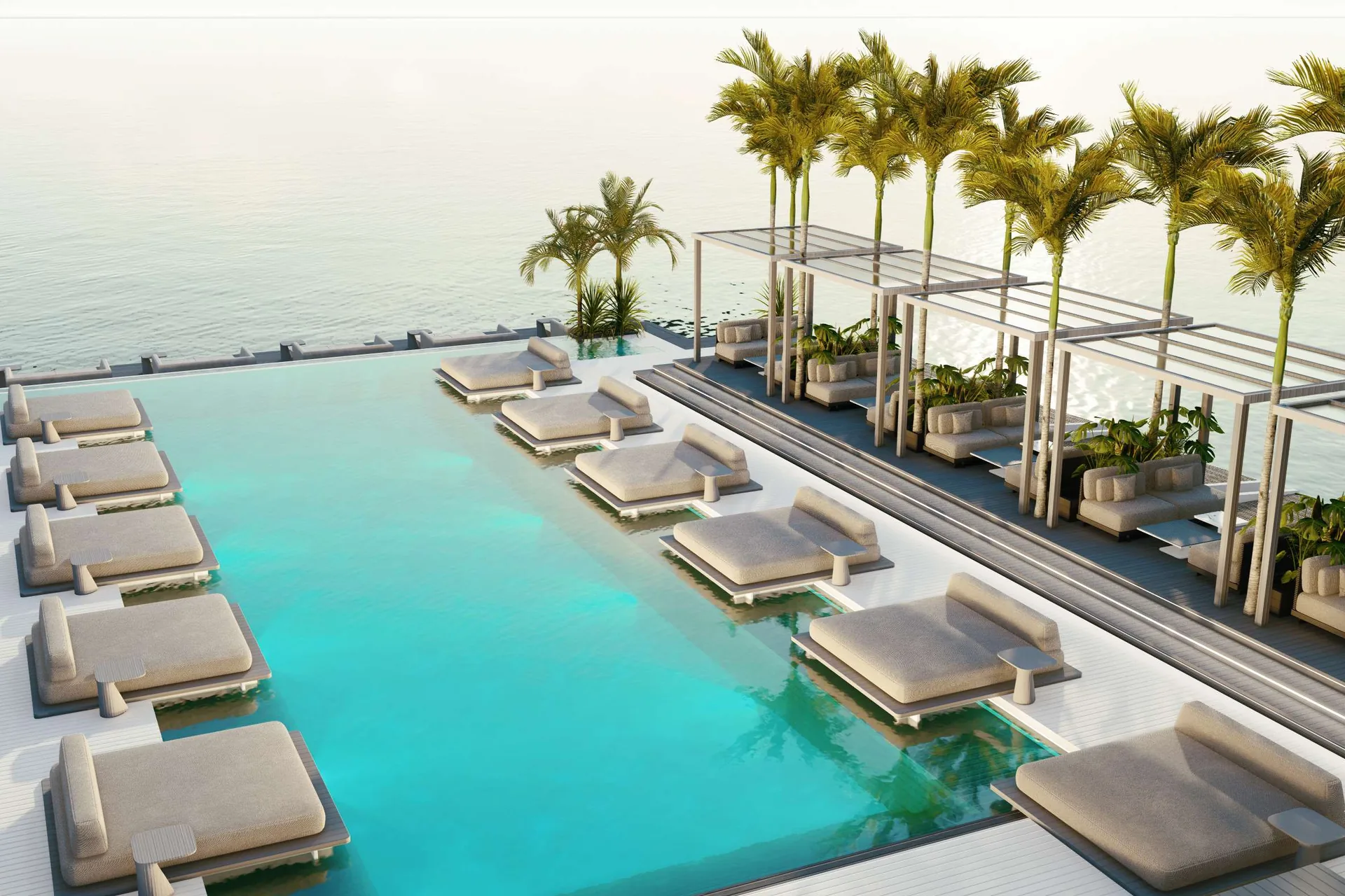 Render of the infinity pool meeting the sea, daybeds along its edge