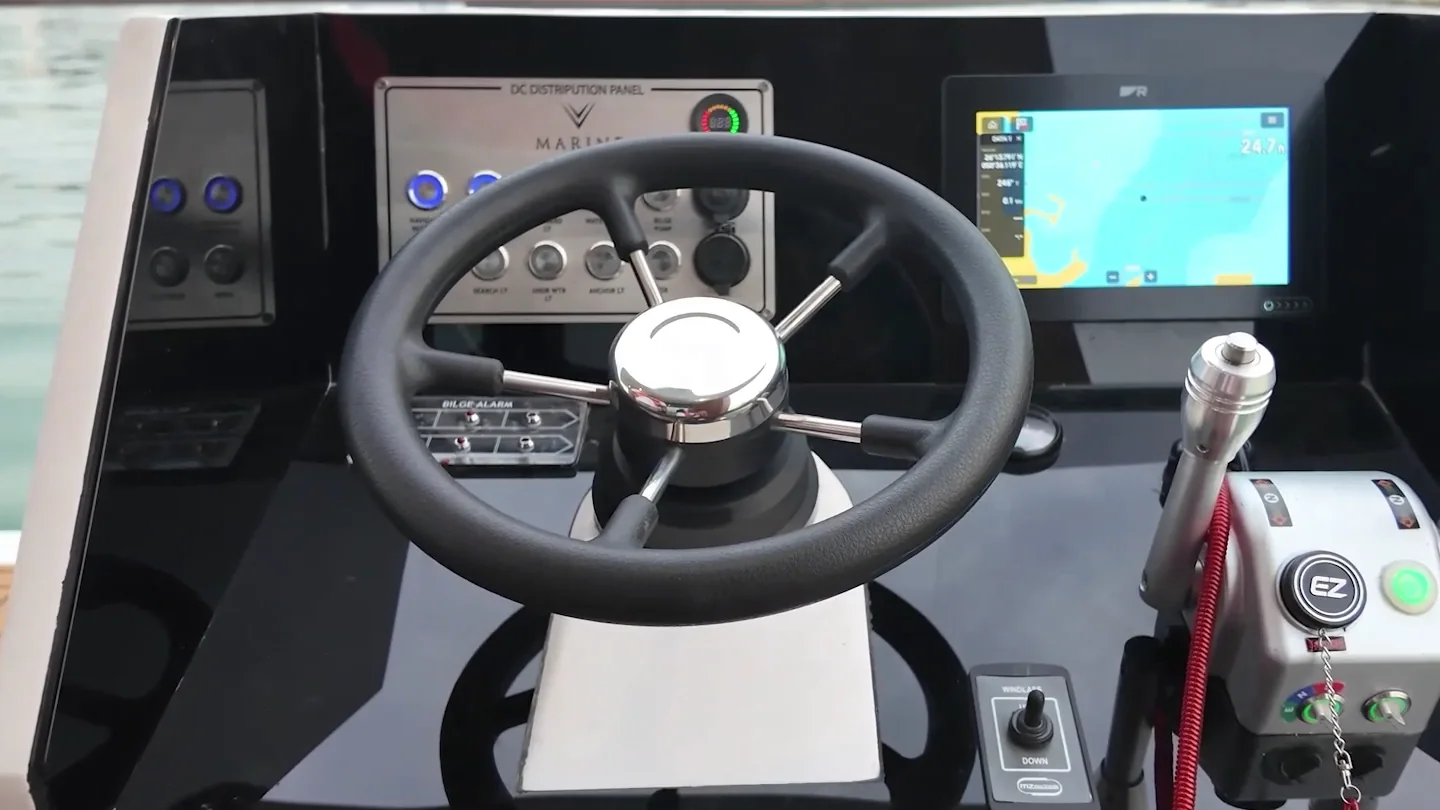 The helm with a steering wheel, chart display and electric throttle controls