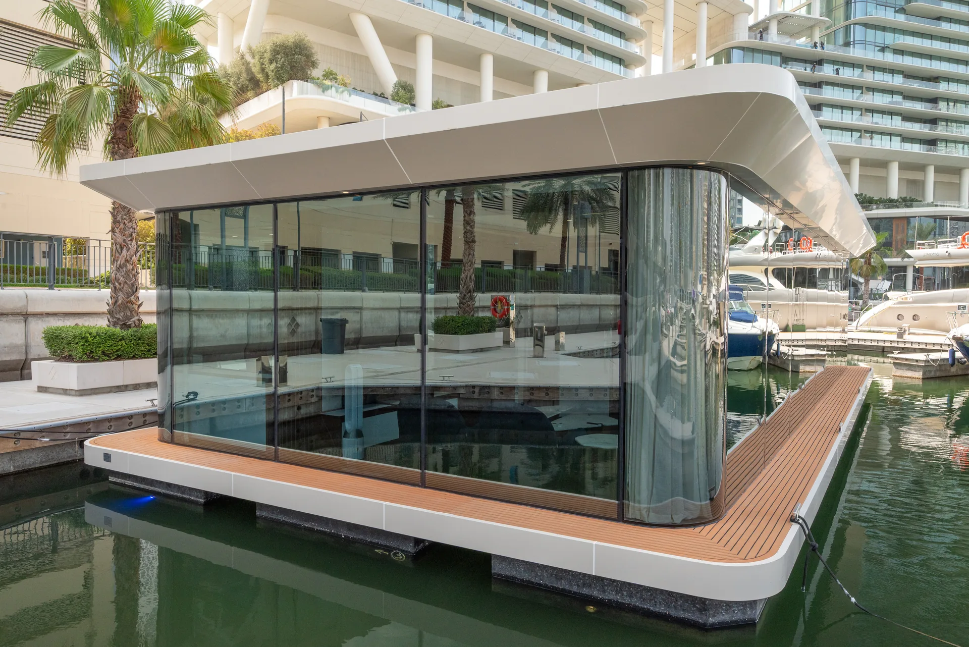 The office by day, its curved canopy over glass walls and a teak-edged deck