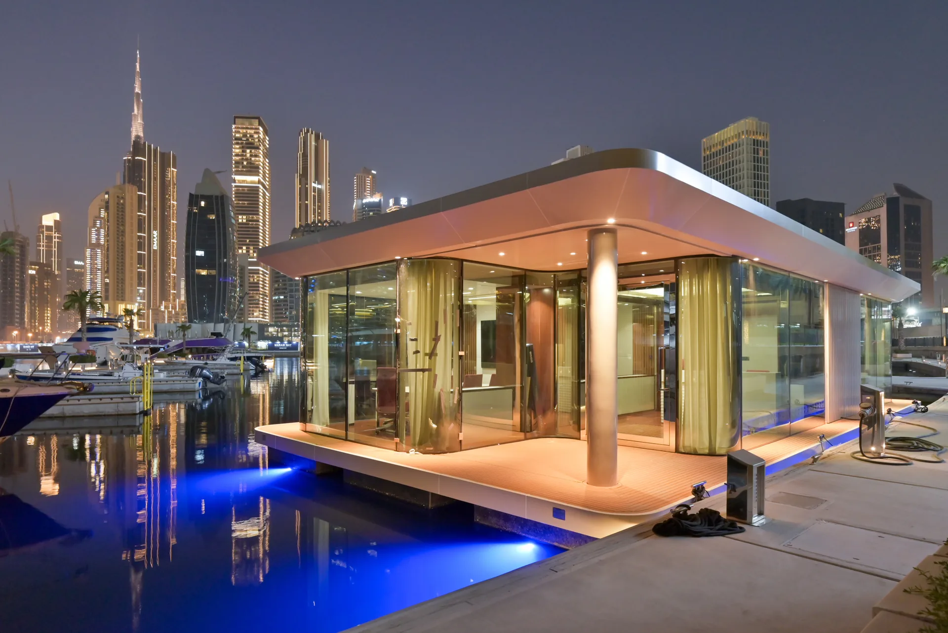 The office at dusk with full-height glass and a city skyline behind
