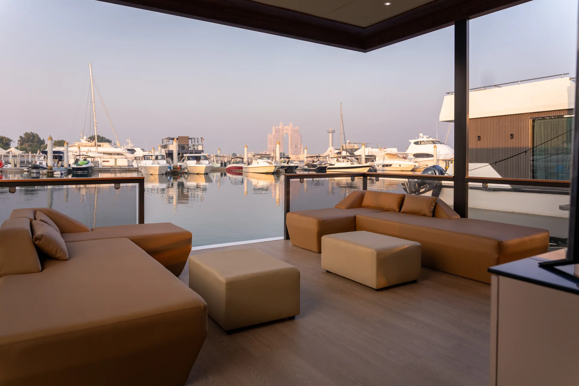 Covered terrace with lounge seating looking over the marina at dusk