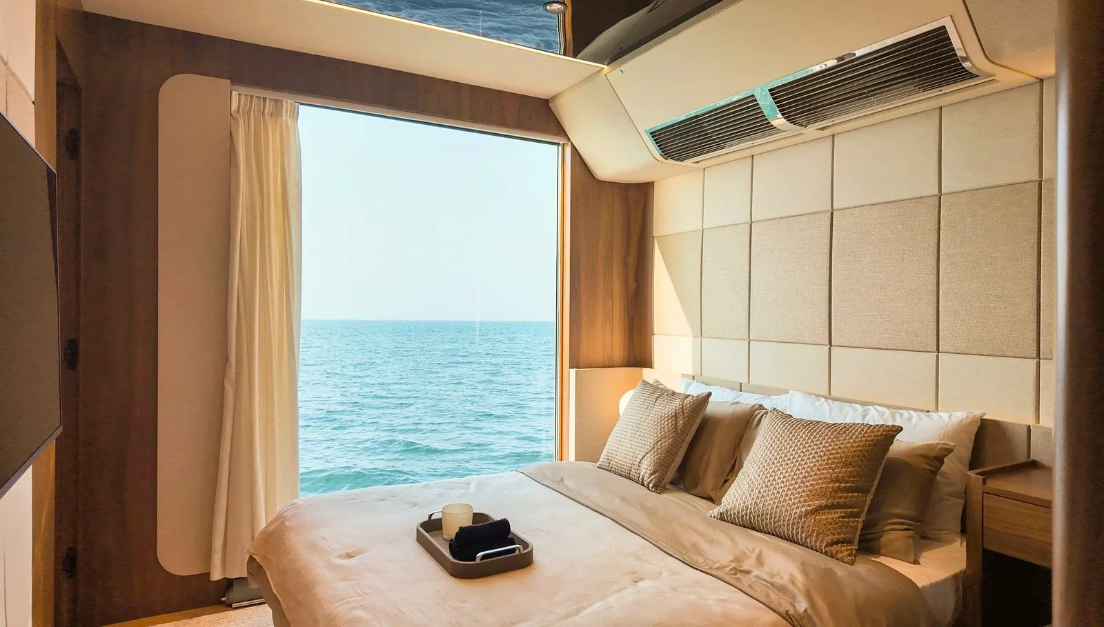 RISE 70 master bedroom with a full-height window onto the sea