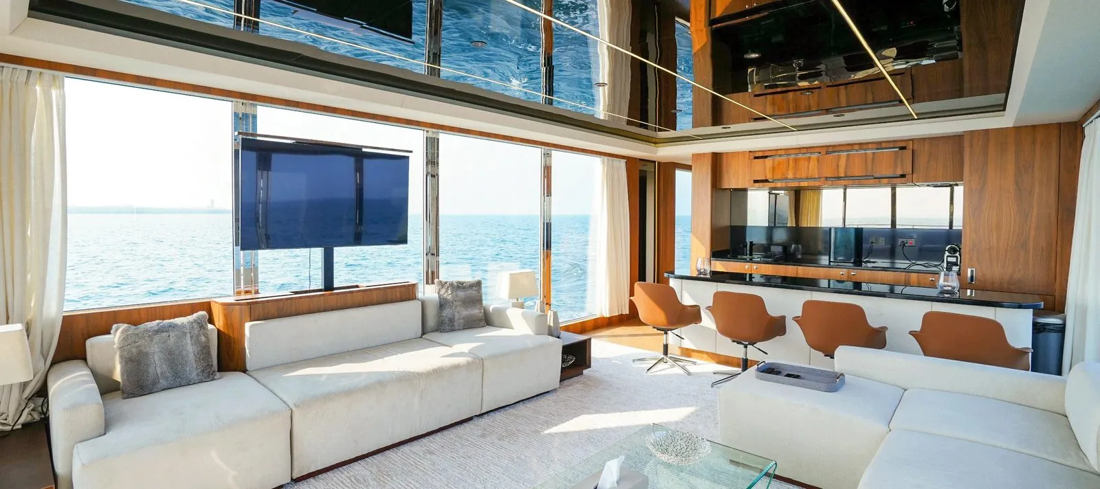 RISE saloon with a long sofa and the sea through floor-to-ceiling glass